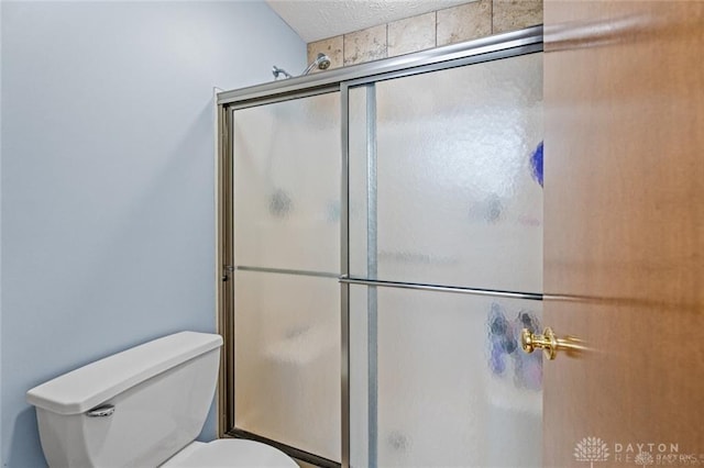 bathroom with a shower with door and toilet