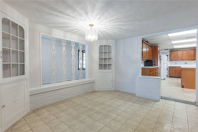 tiled empty room with a chandelier