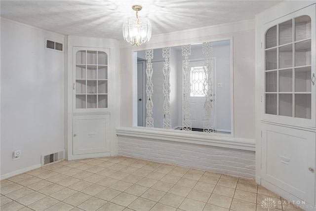 tiled empty room with a notable chandelier