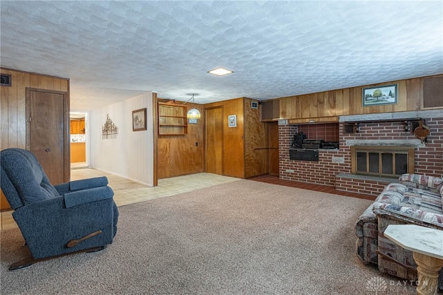 living room with light carpet, wooden walls, and a brick fireplace