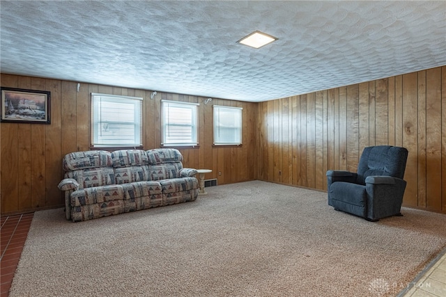 living room featuring wooden walls, carpet floors, and a textured ceiling