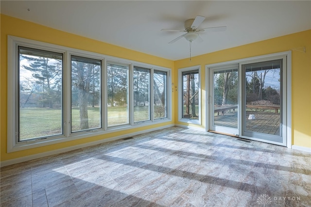 unfurnished sunroom featuring ceiling fan