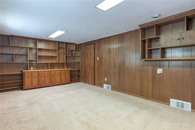 interior space featuring light carpet and wooden walls