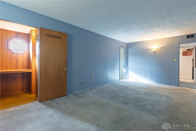 empty room with carpet and a textured ceiling