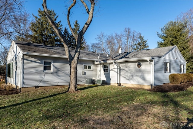 rear view of property featuring a lawn and central AC