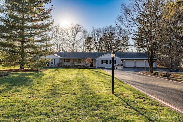 single story home with a garage and a front lawn