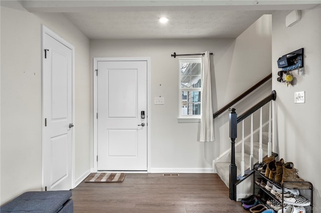 entrance foyer featuring dark wood-type flooring and a textured ceiling