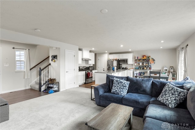 living room with hardwood / wood-style flooring, a wealth of natural light, and a textured ceiling