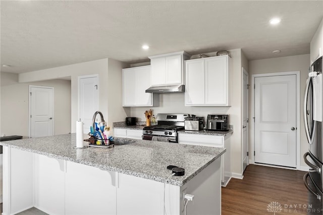 kitchen with a kitchen island with sink, sink, stainless steel appliances, and light stone countertops