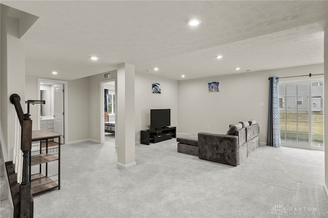 carpeted living room featuring a textured ceiling