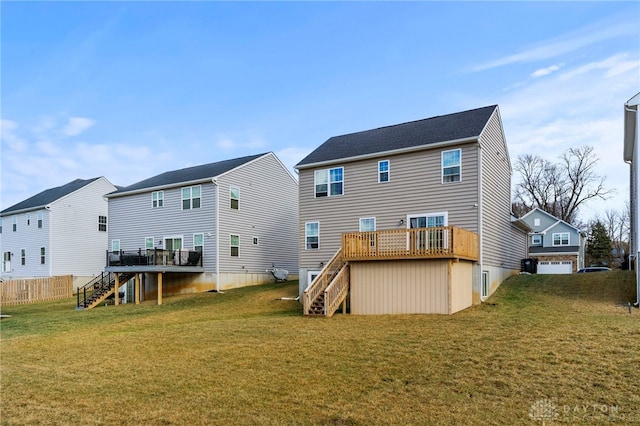 rear view of house with a deck and a lawn