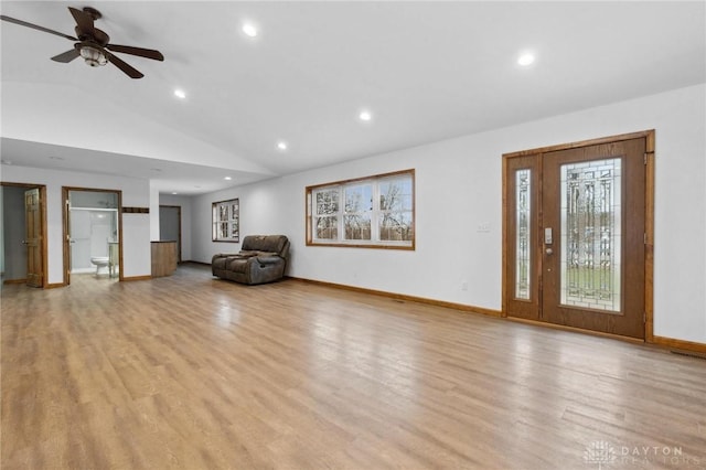 unfurnished living room featuring ceiling fan, vaulted ceiling, and light wood-type flooring