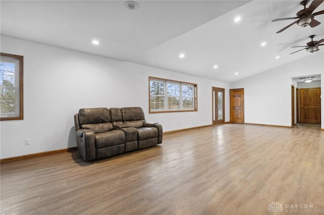 living room with plenty of natural light, light hardwood / wood-style floors, and vaulted ceiling