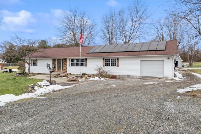 single story home featuring a garage and solar panels