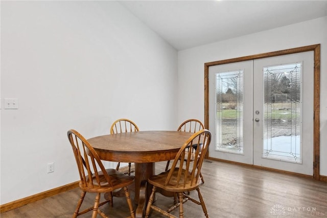 dining space with wood-type flooring and french doors