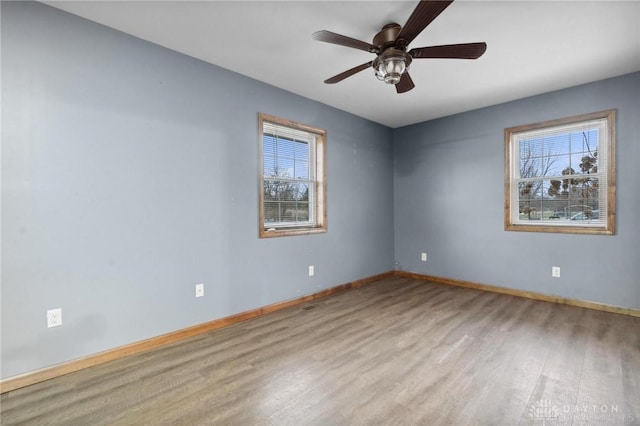 unfurnished room featuring a wealth of natural light, light hardwood / wood-style flooring, and ceiling fan