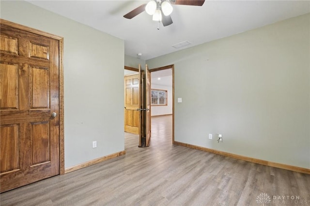 empty room featuring ceiling fan and light hardwood / wood-style flooring