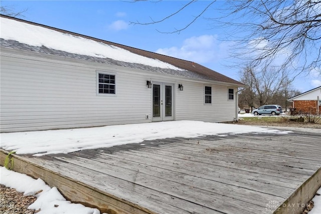 snow covered deck featuring french doors