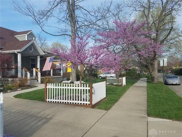 view of side of home featuring a porch and a yard