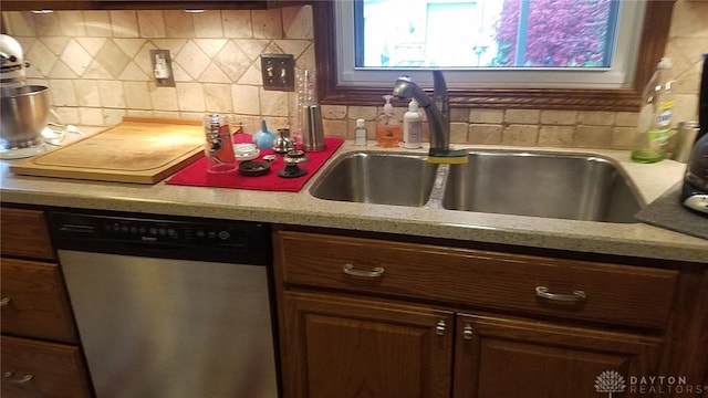 kitchen featuring dark brown cabinetry, dishwasher, sink, and decorative backsplash