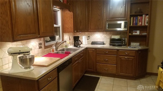 kitchen featuring appliances with stainless steel finishes, sink, light tile patterned floors, and backsplash