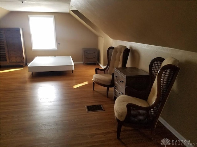 sitting room with dark hardwood / wood-style flooring and vaulted ceiling