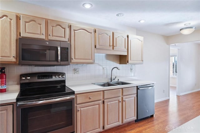 kitchen with sink, decorative backsplash, stainless steel appliances, and light brown cabinets