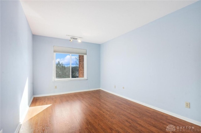 spare room with wood-type flooring