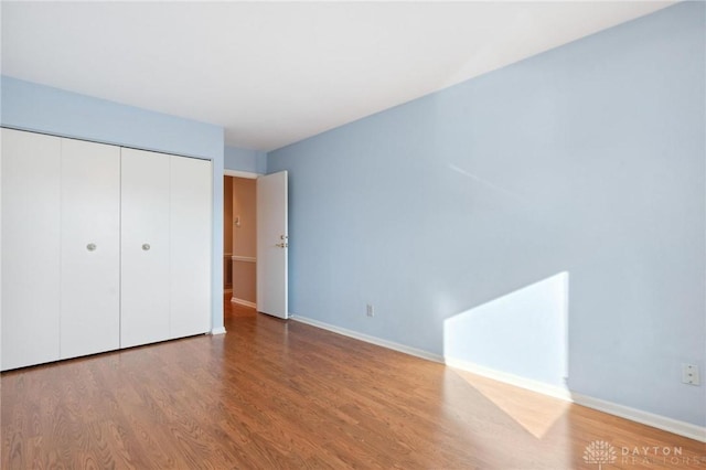 unfurnished bedroom with hardwood / wood-style floors and a closet