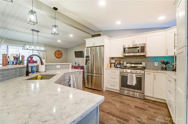 kitchen featuring white cabinetry, sink, pendant lighting, and stainless steel appliances