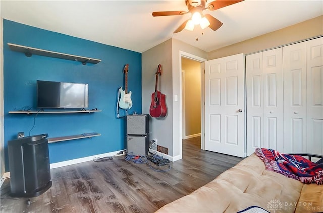 interior space with dark wood-type flooring, ceiling fan, and a closet