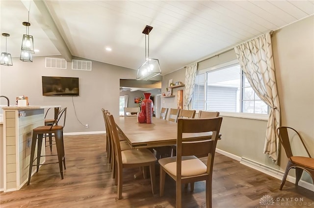 dining area featuring vaulted ceiling with beams and dark wood-type flooring