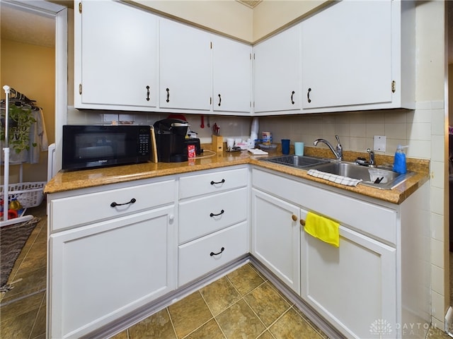 kitchen featuring white cabinetry, backsplash, and sink