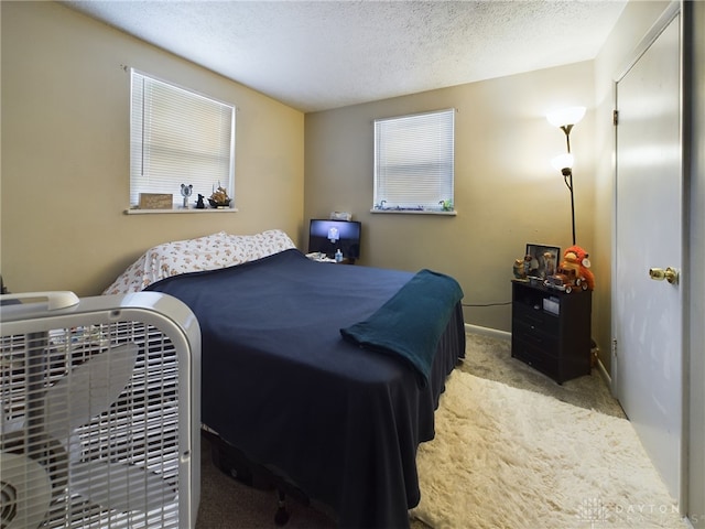 bedroom featuring light carpet and a textured ceiling