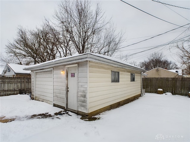 snow covered structure with a garage