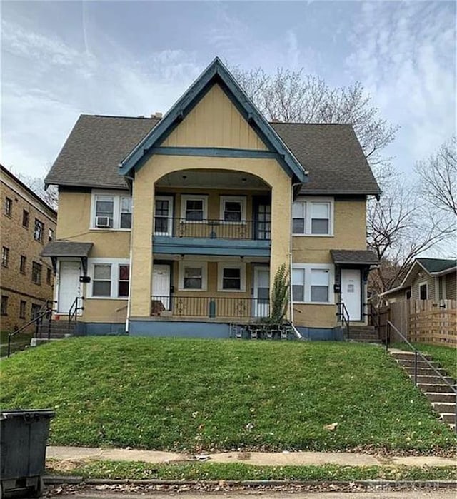 view of front of home featuring a balcony and a front lawn