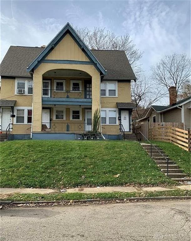 view of front of home featuring a front yard and a balcony