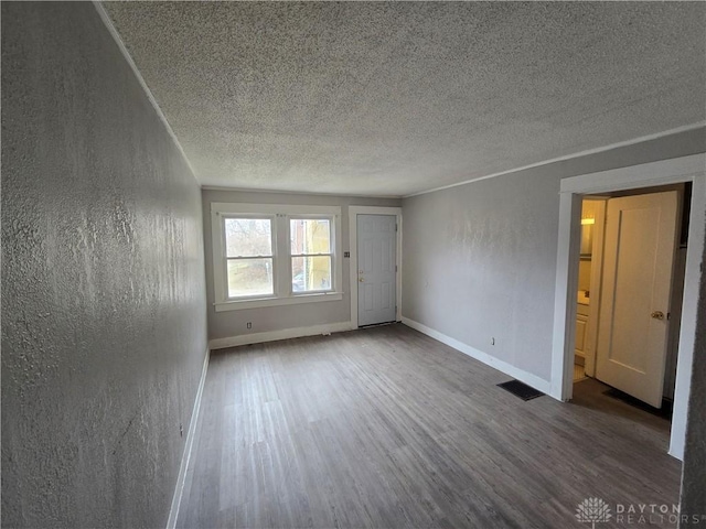 unfurnished room with hardwood / wood-style floors and a textured ceiling