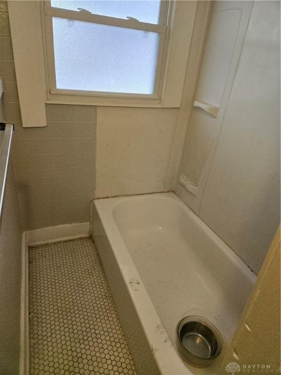 bathroom with a tub to relax in and plenty of natural light