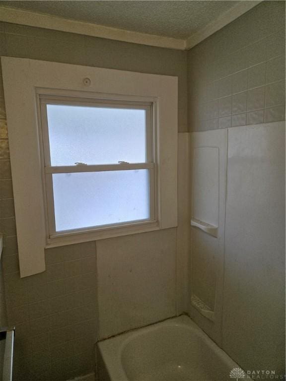 bathroom with ornamental molding and a textured ceiling