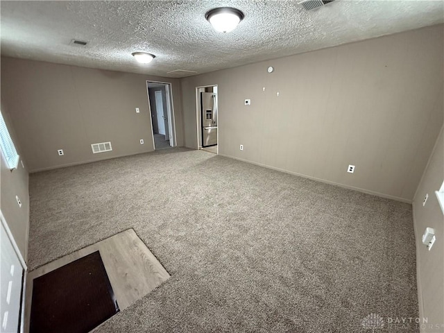 carpeted spare room featuring a textured ceiling