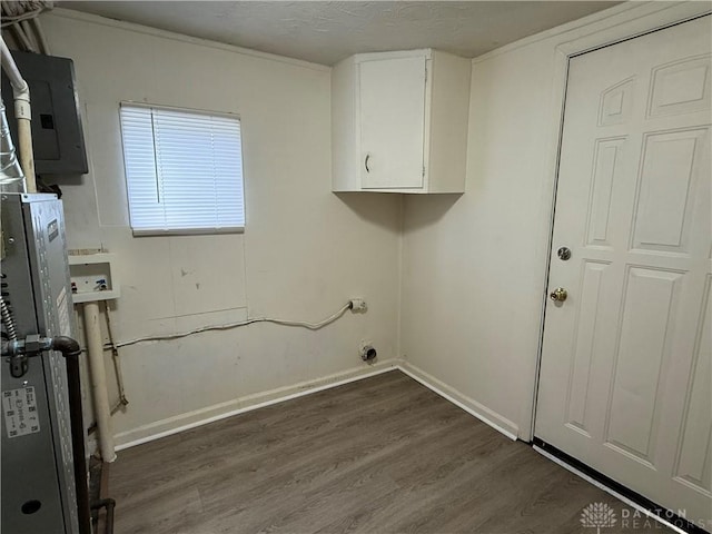 washroom with hookup for a washing machine, dark hardwood / wood-style floors, electric panel, and cabinets