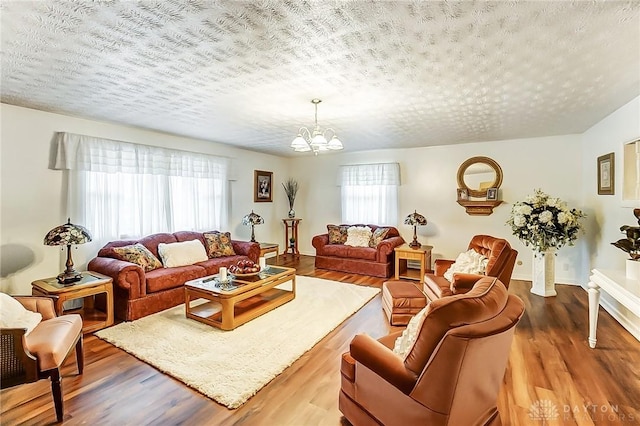 living room with hardwood / wood-style floors, a notable chandelier, and a textured ceiling