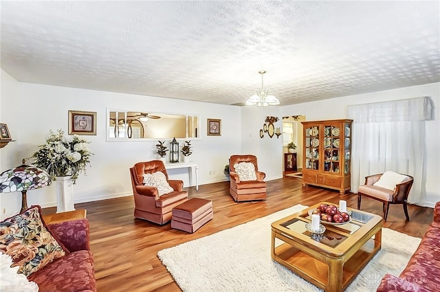 living room with a chandelier, hardwood / wood-style floors, and a textured ceiling