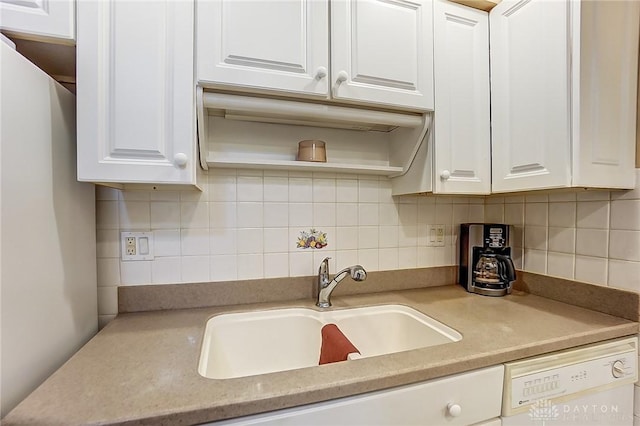 kitchen with backsplash, dishwasher, sink, and white cabinets