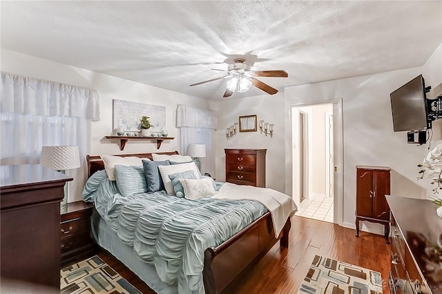 bedroom with dark hardwood / wood-style flooring, a textured ceiling, and ceiling fan