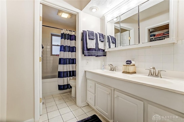 full bathroom with tile patterned floors, toilet, vanity, shower / bath combo with shower curtain, and backsplash