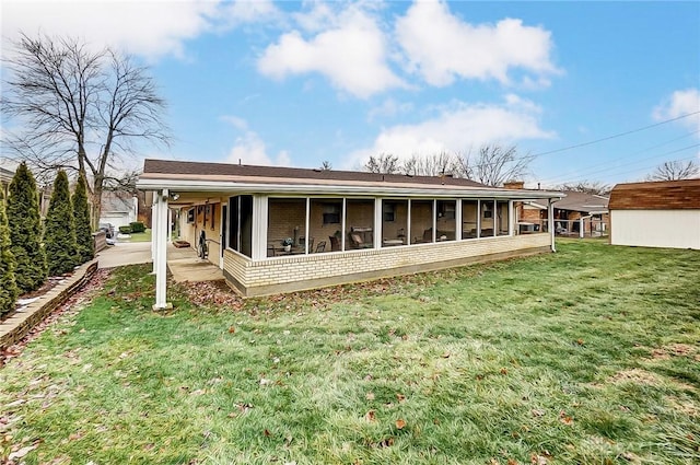 rear view of property featuring a yard and a sunroom