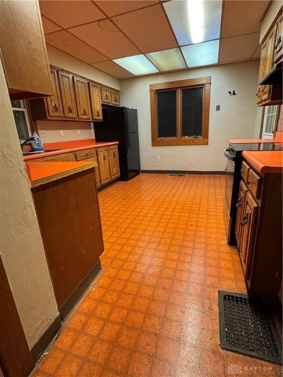 kitchen featuring a drop ceiling, sink, and black appliances