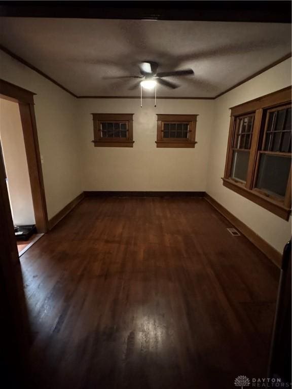 spare room with crown molding, ceiling fan, and dark hardwood / wood-style flooring